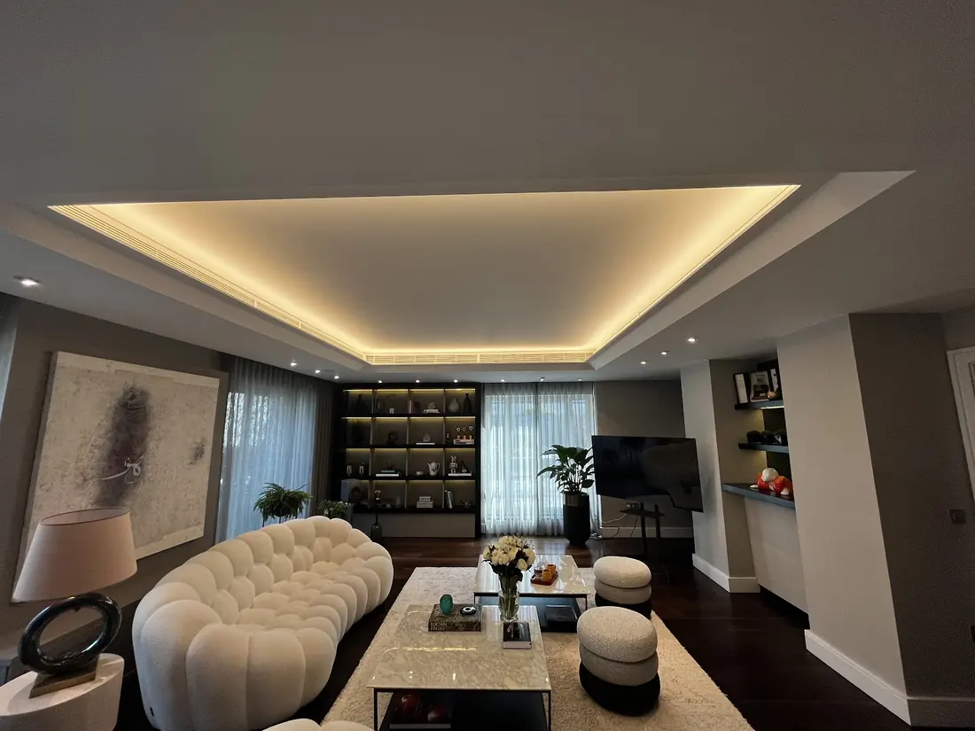 Living room with recessed cove LED lighting and integrated shelf lighting